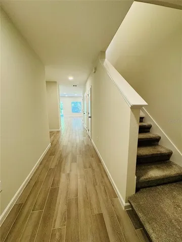 a view of a hallway with wooden floor