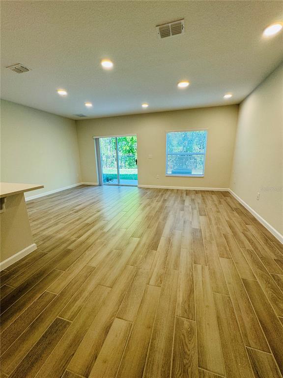 4906 Livingston Lane Oviedo, FL 32765 - Photo 7 of 25 an empty room with wooden floor and a window