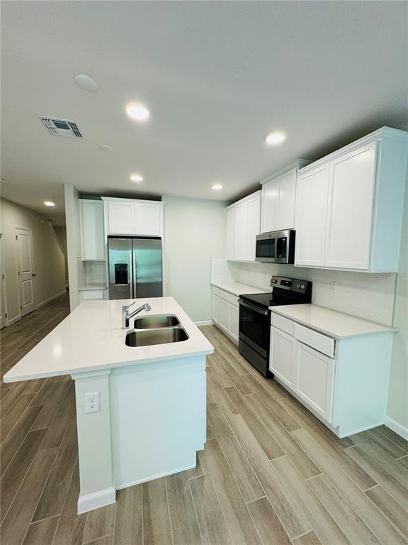4906 Livingston Lane Oviedo, FL 32765 - Photo 9 of 25 a kitchen with stainless steel appliances granite countertop a sink and white cabinets