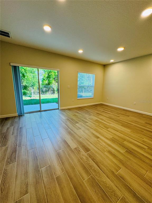 4906 Livingston Lane Oviedo, FL 32765 - Photo 10 of 25 an empty room with wooden floor and windows