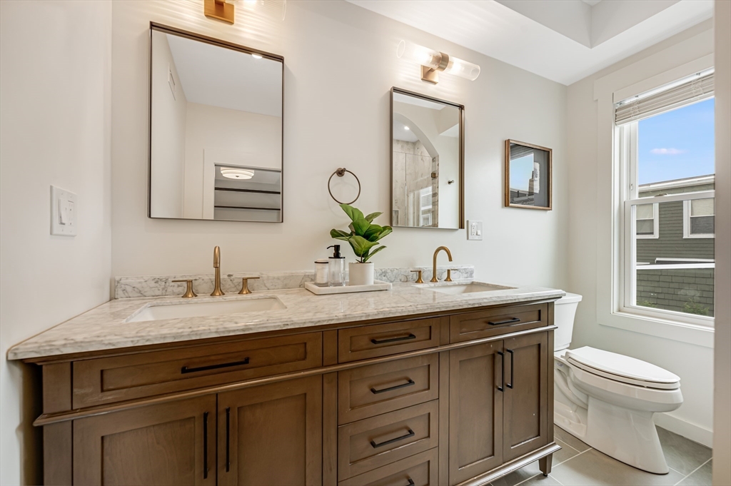 18 Loring Street Boston, MA 02127 - Photo 15 of 27 a bathroom with a granite countertop toilet sink and a mirror
