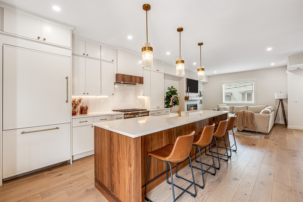 18 Loring Street Boston, MA 02127 - Photo 8 of 27 a kitchen with stainless steel appliances a stove a sink a refrigerator and white cabinets with wooden floor