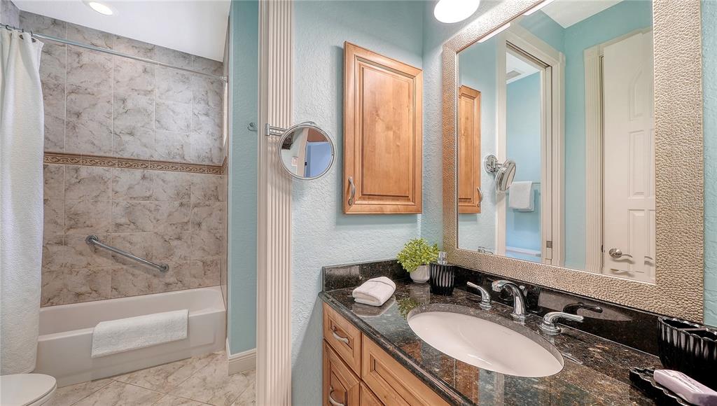 1630 Assisi Drive, Unit 18 Sarasota, FL 34231 - Photo 26 of 42 a bathroom with a granite countertop sink a toilet and shower
