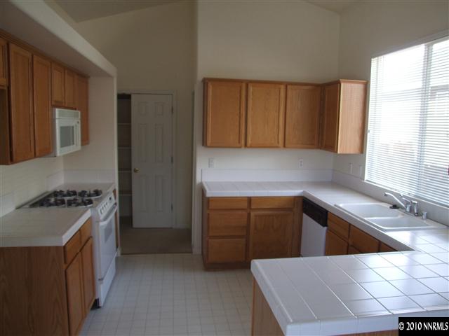 7448 Celeste Drive Reno, NV 89511 - Photo 3 of 3 a kitchen with a stove a sink a refrigerator and cabinets