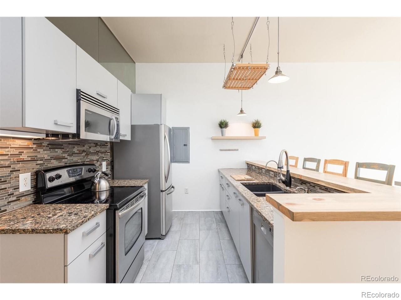 3100 Huron Street, Unit 3P Denver, CO 80202 - Photo 15 of 34 a kitchen with stainless steel appliances granite countertop a stove a sink dishwasher and a refrigerator