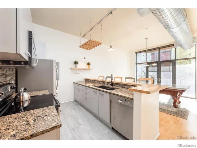 a kitchen with stainless steel appliances kitchen island granite countertop a sink stove and cabinets