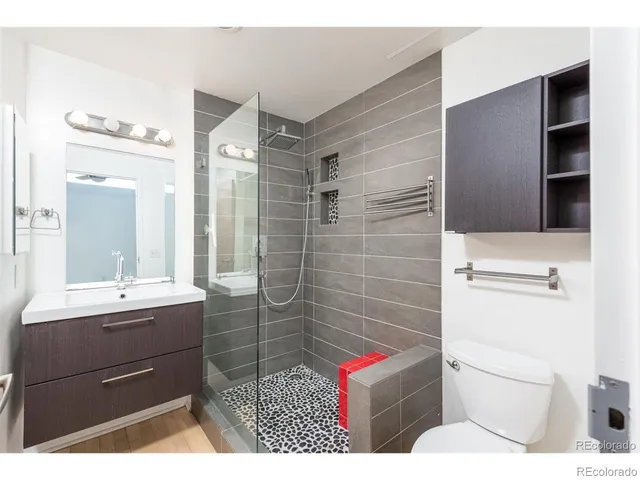 a bathroom with a sink a toilet and shower