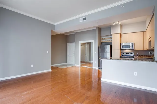 a view of empty room with wooden floor
