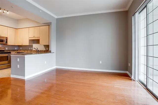 a view of a kitchen with a sink and dishwasher a stove top oven with wooden floor