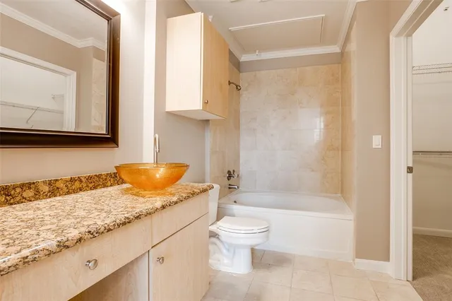 a bathroom with a granite countertop sink a toilet and bathtub