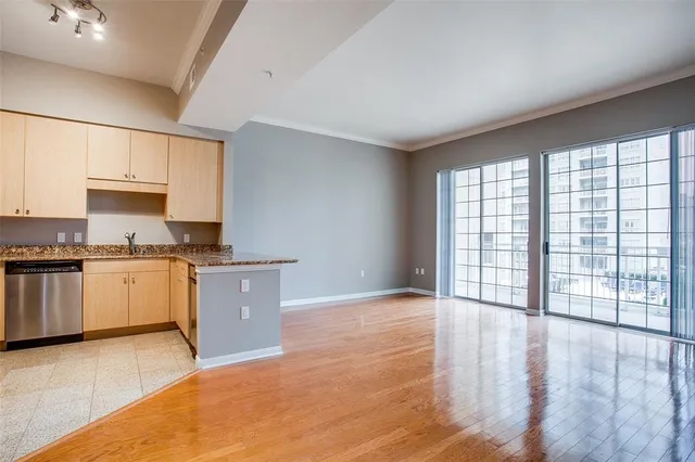 a kitchen with granite countertop a stove a sink and white cabinets with wooden floor