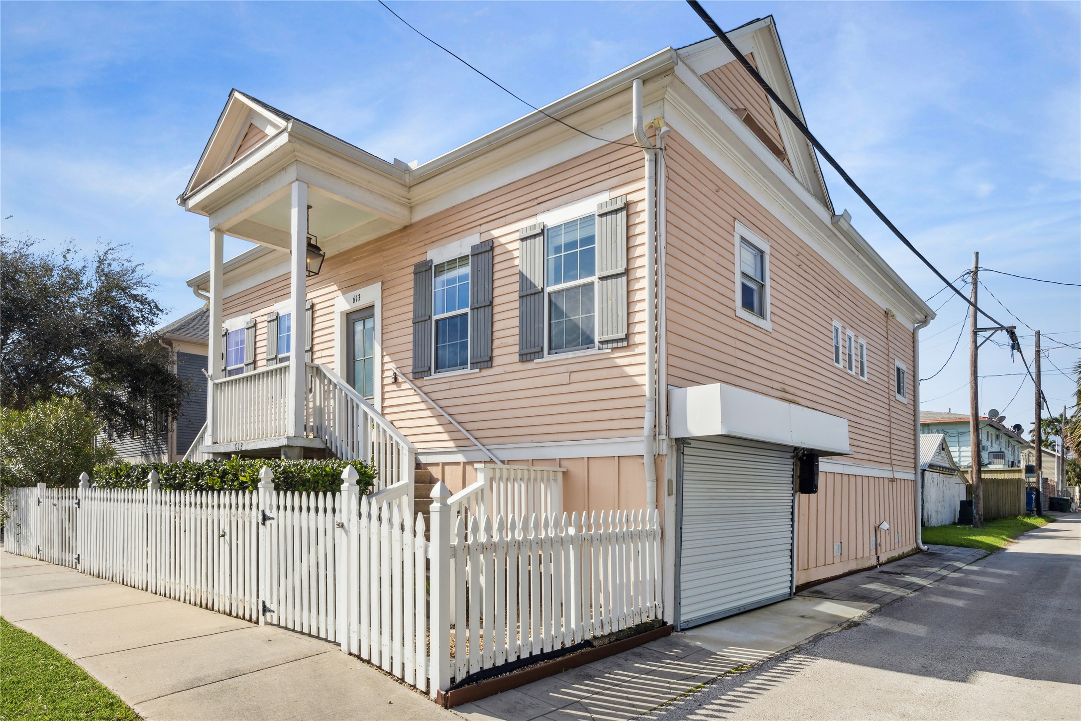 613 9th Street Galveston, TX 77550 - Photo 29 of 35 a view of a house with a small yard and wooden fence and floor to ceiling windows