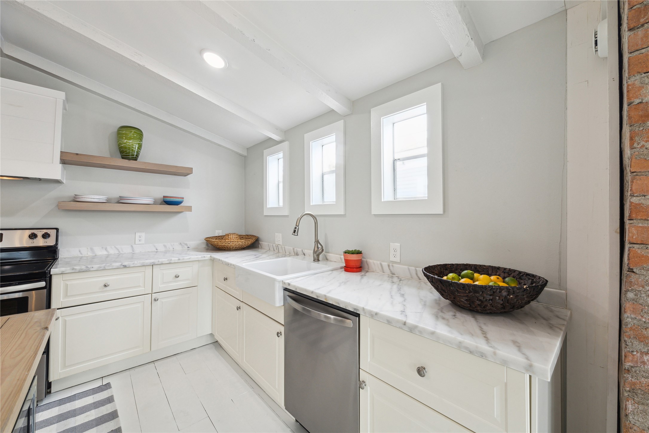 613 9th Street Galveston, TX 77550 - Photo 9 of 35 a kitchen with stainless steel appliances granite countertop a sink a stove and cabinets