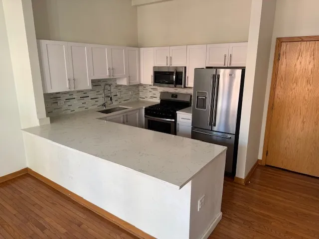 a kitchen with a refrigerator a stove top oven a sink and dishwasher
