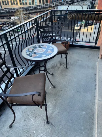 a view of a chairs and table in the balcony