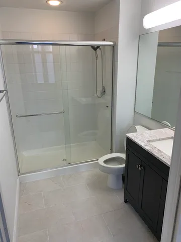 a bathroom with a granite countertop sink toilet and shower