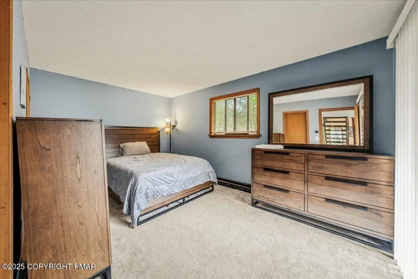 a bedroom with a bed and a dresser next to a window