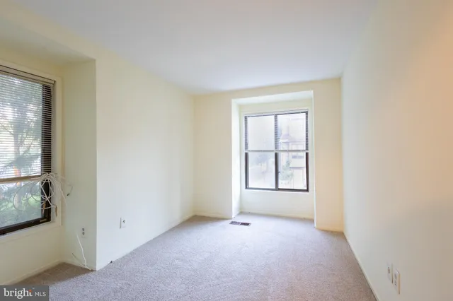 an empty room with windows and closet