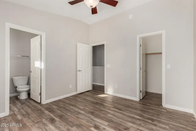 an empty room and a bathroom with a toilet