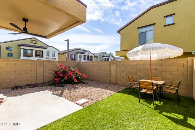 a backyard of a house with table and chairs