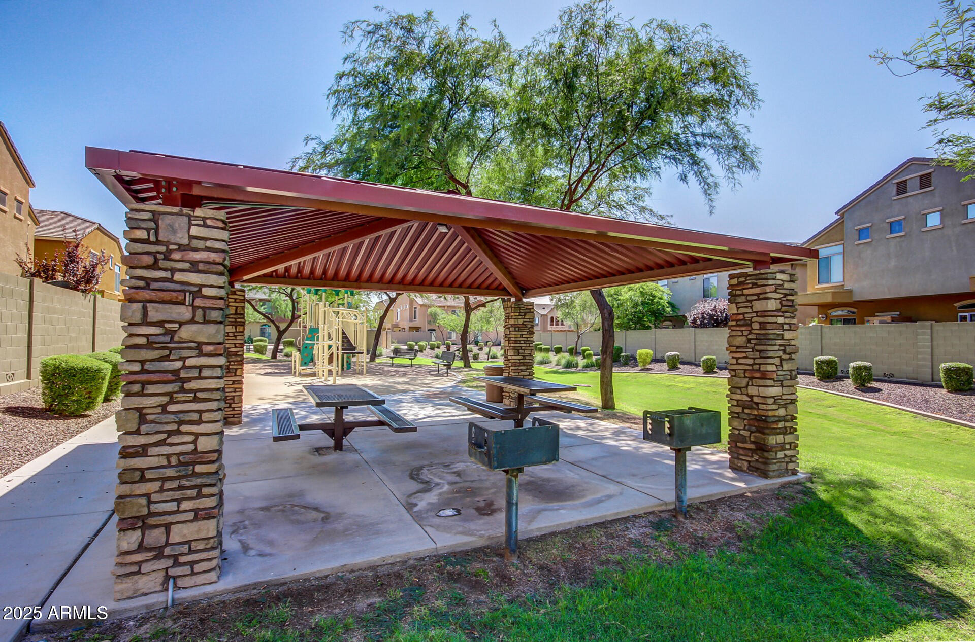 2725 East Mine Creek Road, Unit 1010 Phoenix, AZ 85024 - Photo 28 of 35 a view of a patio with table and chairs under an umbrella with a fire pit