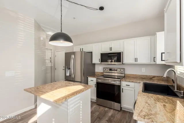 a kitchen with stainless steel appliances granite countertop a sink stove and refrigerator