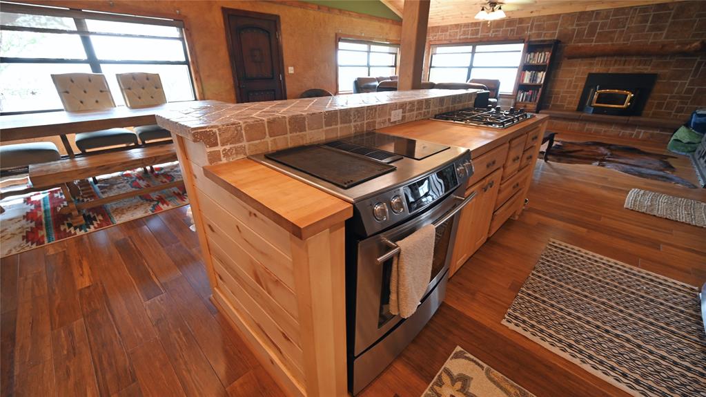 2377 Casino Road Nocona, TX 76255 - Photo 17 of 40 a kitchen with granite countertop a stove and a wooden floor