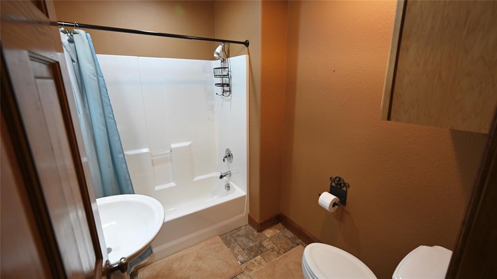 2377 Casino Road Nocona, TX 76255 - Photo 24 of 40 a bathroom with a shower and toilet