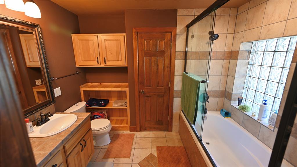 2377 Casino Road Nocona, TX 76255 - Photo 34 of 40 a bathroom with a sink a toilet and a shower