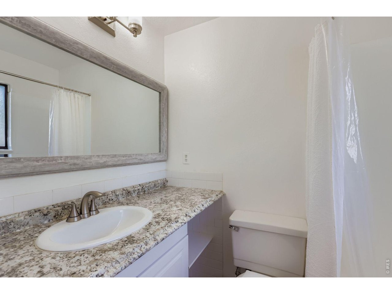 720 17th Street Boulder, CO 80302 - Photo 14 of 35 a bathroom with a granite countertop sink and a mirror