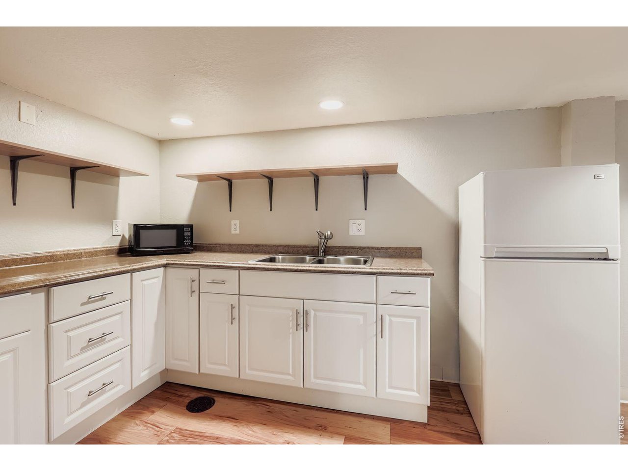 720 17th Street Boulder, CO 80302 - Photo 22 of 35 a kitchen with granite countertop white cabinets and refrigerator