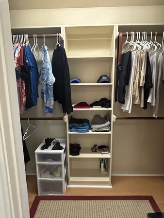 a view of walk in closet with clothes and shoes