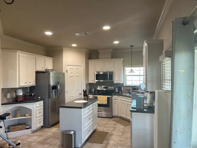 a kitchen with stainless steel appliances granite countertop a refrigerator stove microwave and sink