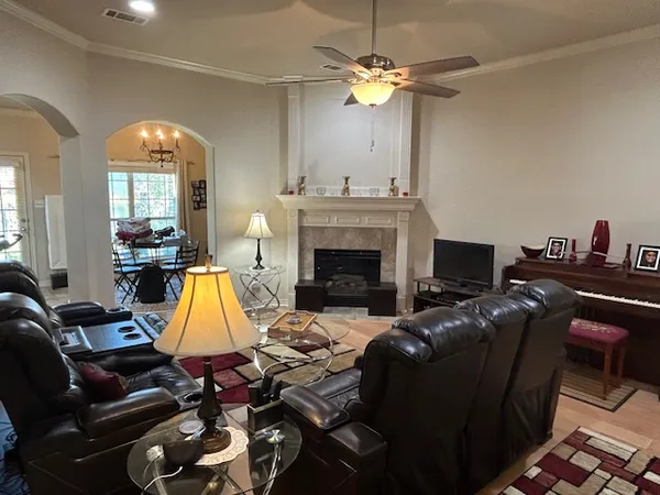 a living room with furniture a fireplace and a chandelier