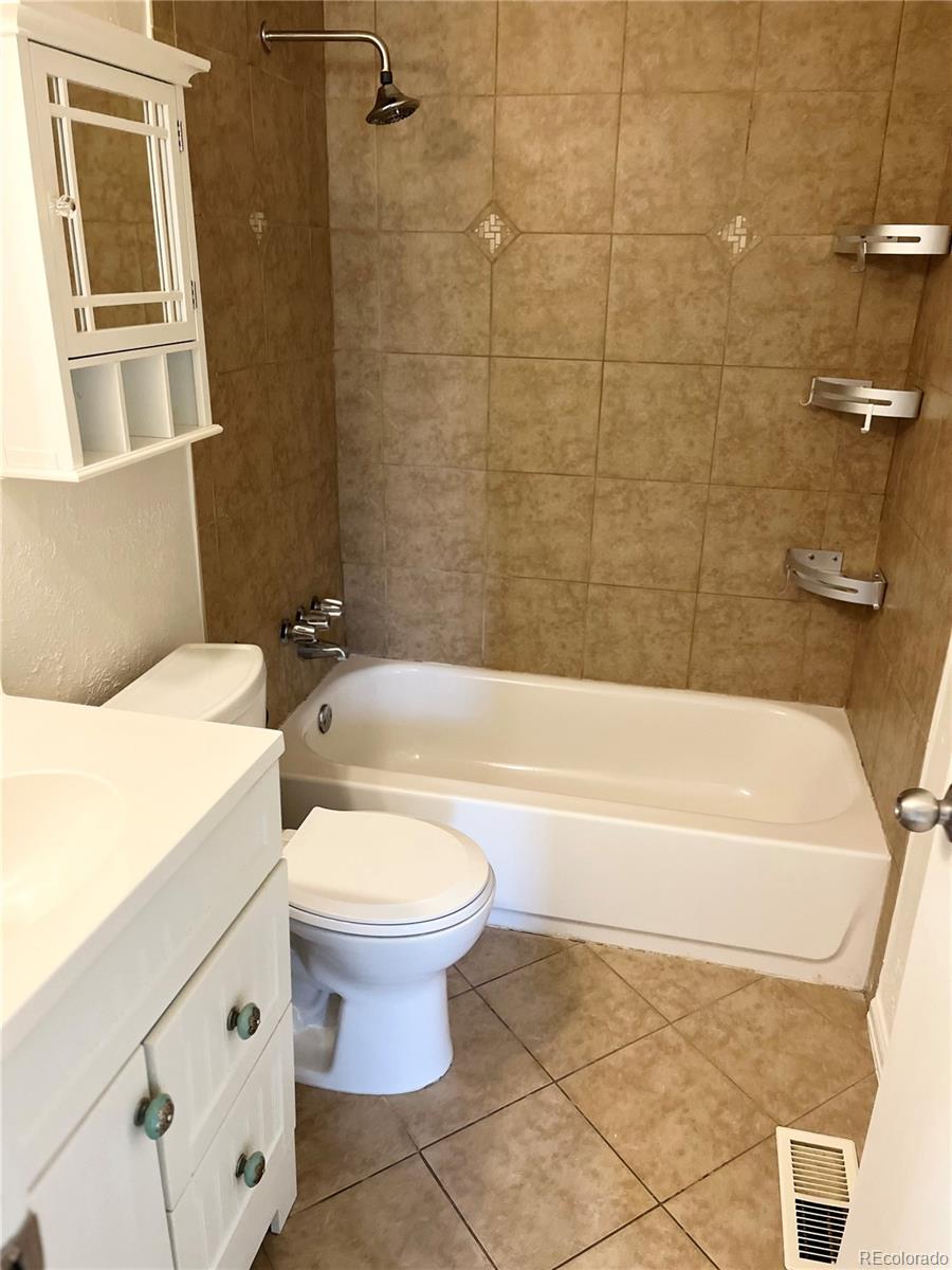19406 East Purdue Place Aurora, CO 80013 - Photo 9 of 10 a bathroom with a toilet a sink and bathtub