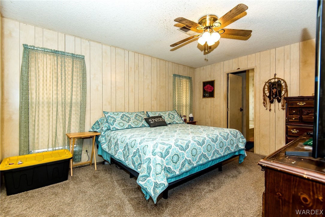 3373 Higley Road Golden Valley, AZ 86413 - Photo 30 of 47 a spacious bedroom with a bed and a chandelier