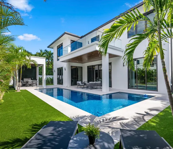 a view of a house with backyard and sitting area