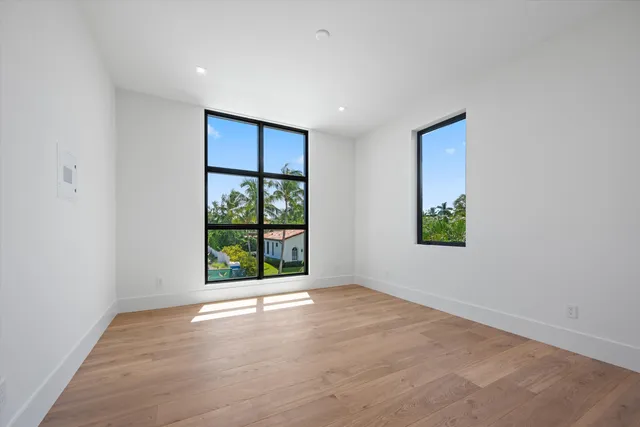 an empty room with wooden floor and a window
