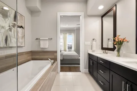 a spacious bathroom with a tub sink and mirror