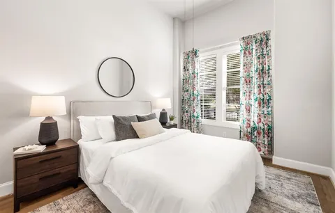 a bedroom with a large bed and wooden floor