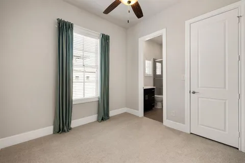an empty room with closet and a chandelier fan
