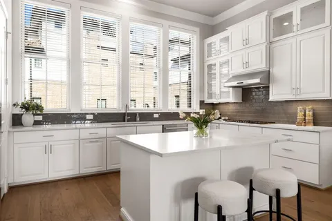 a kitchen with stainless steel appliances granite countertop a stove a sink and white cabinets