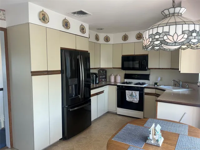 a kitchen with stainless steel appliances granite countertop a refrigerator a stove top oven a sink and dishwasher