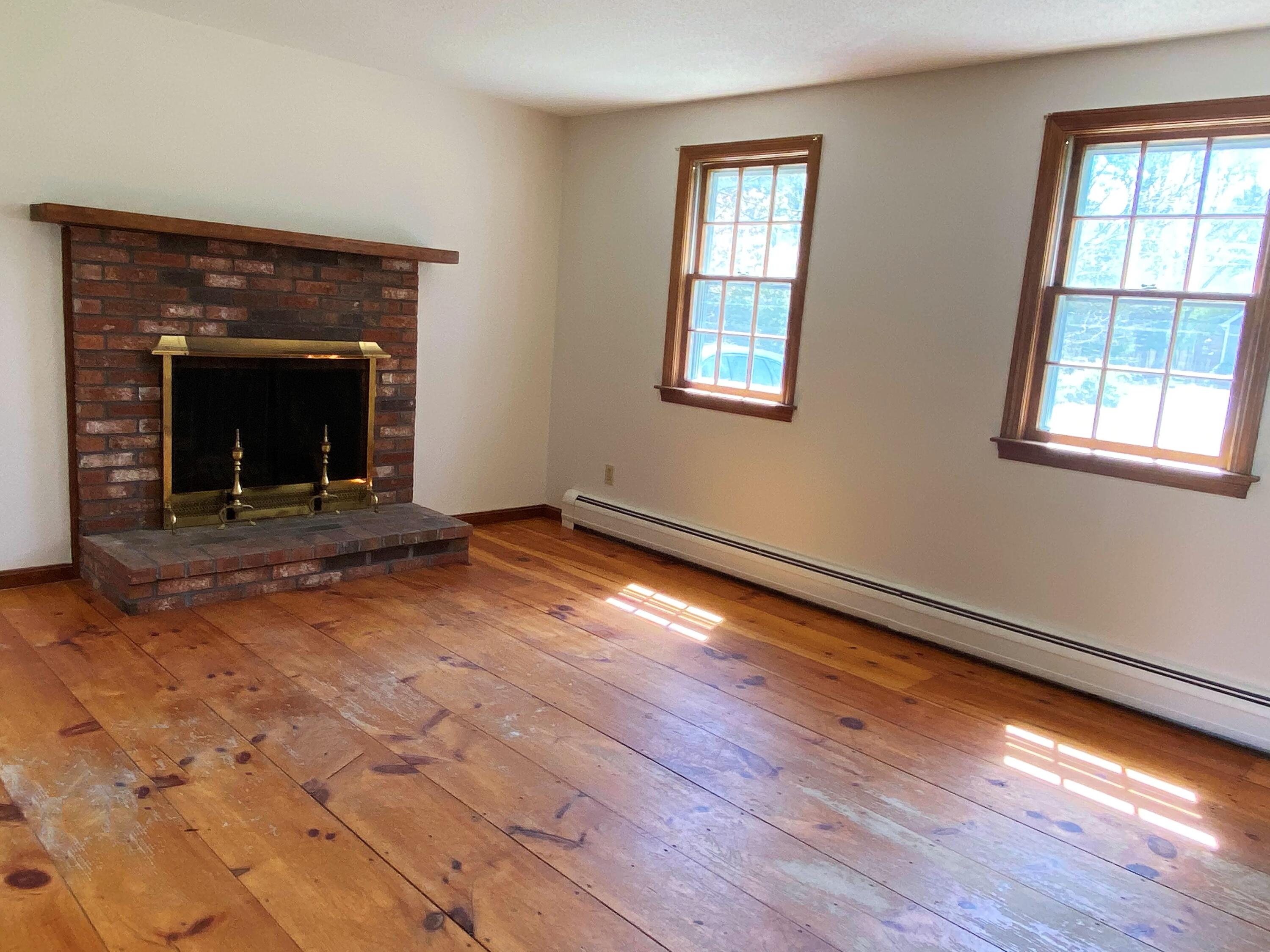 170 Taramac Road Centerville, MA 02632 - Photo 4 of 20 a view of an empty room with wooden floor fireplace and a window