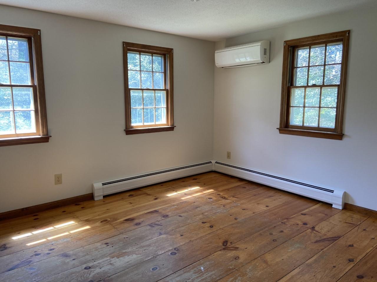 170 Taramac Road Centerville, MA 02632 - Photo 7 of 20 an empty room with wooden floor and windows
