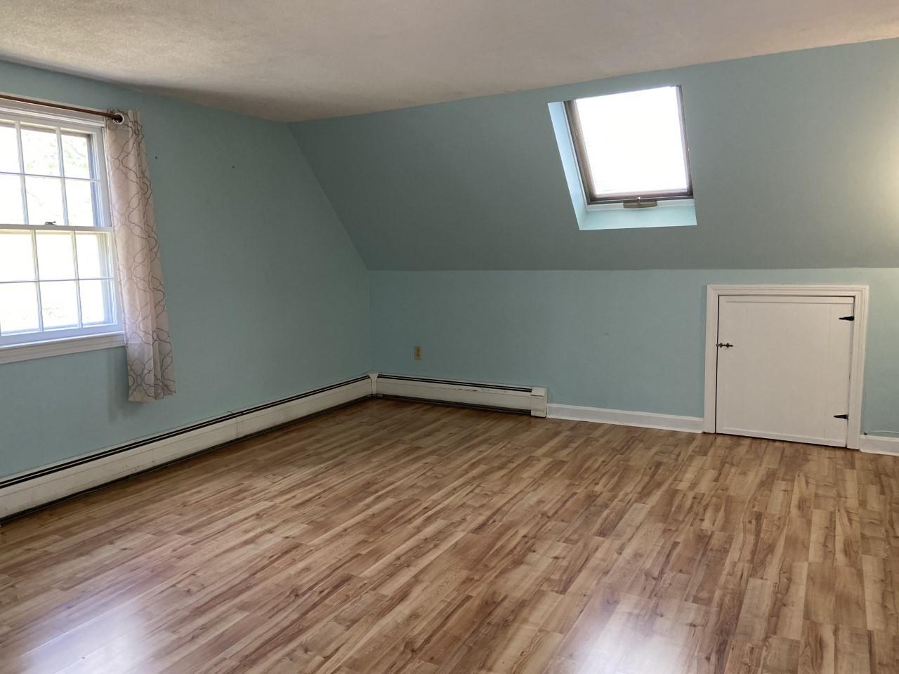 170 Taramac Road Centerville, MA 02632 - Photo 10 of 20 an empty room with wooden floor and windows