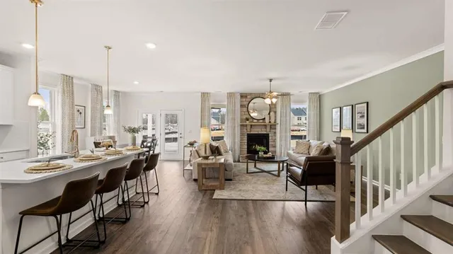 a living room with furniture a fireplace and a kitchen view