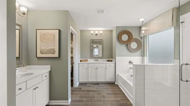 a en suite bathroom with double sink a toilet a mirror and shower