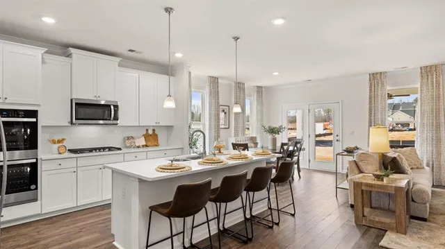 a dining room with wooden floor a chandelier a wooden table and chairs