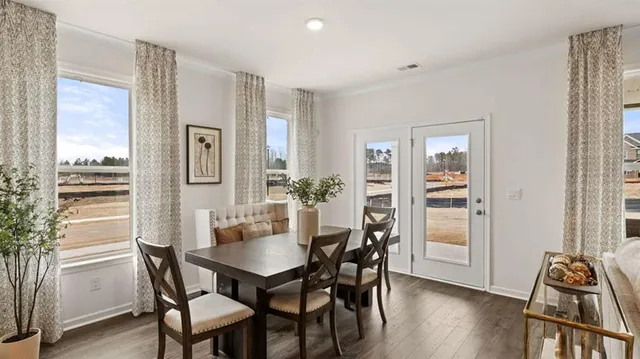 a kitchen with a dining table chairs and white cabinets